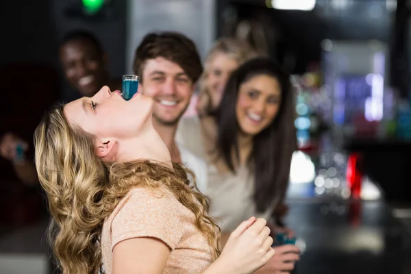 Blonde woman with a shot in her mouth — Stock Photo, Image