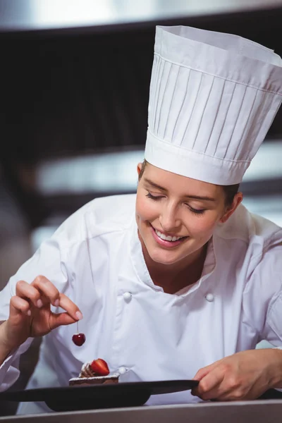 Chef putting a cherry on a dessert — Stock Photo, Image