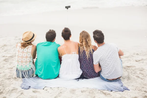 Bakifrån av vän med en selfie på stranden — Stockfoto