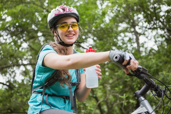 Женщина пьет воду во время езды на велосипеде — стоковое фото