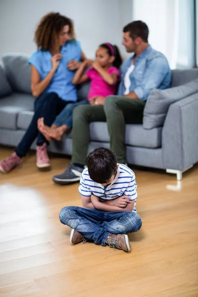Расстроенный мальчик сидит на полу со скрещенными руками — стоковое фото