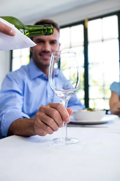 Servitören hälla vin i glas med kund — Stockfoto