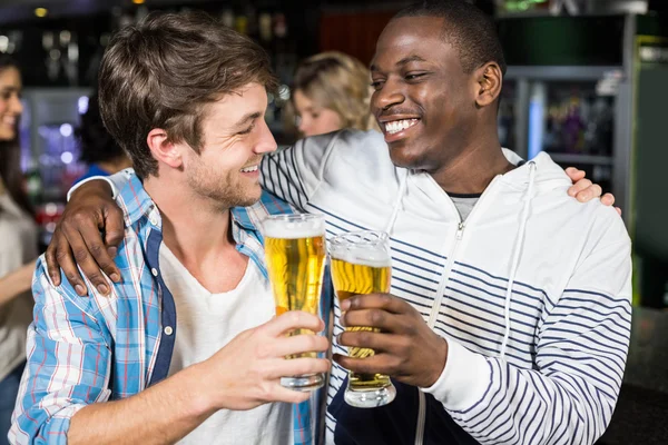 Lächelnde Freunde beim Bier mit ihren Freunden — Stockfoto