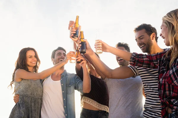 Glückliche Freunde, die Bierflaschen anheben — Stockfoto