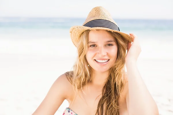 Pretty woman in bikini and hat sitting on the beach — Stock Photo, Image