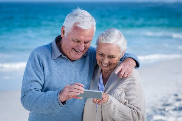 Ładny starsza para patrząc smartphone — Zdjęcie stockowe