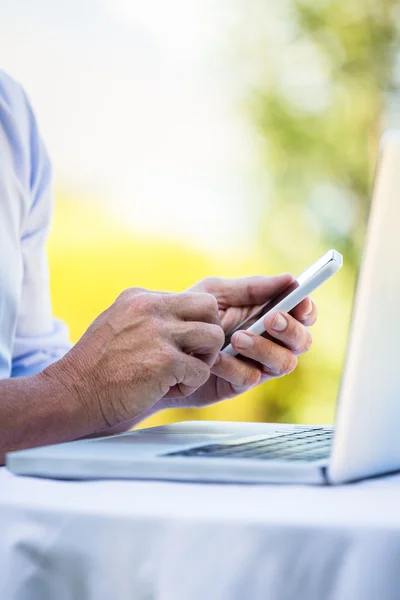 Casual zakenman met laptop en smartphone — Stockfoto