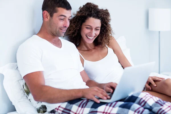 Casal feliz usando laptop na cama — Fotografia de Stock