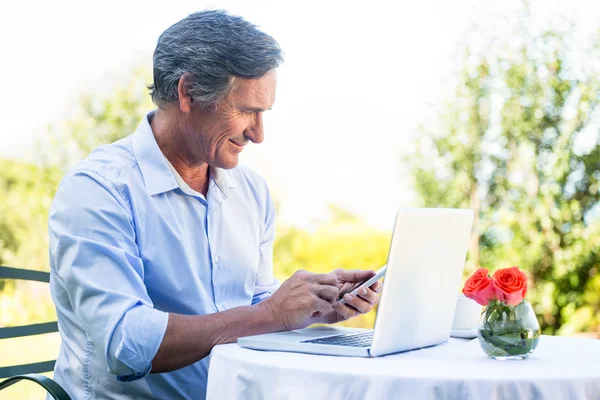 Casual businessman using laptop and smartphone — Stock Photo, Image