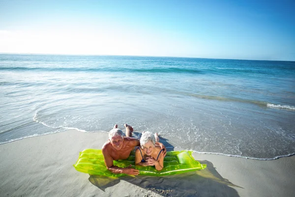 Senior couple lying on air mattress — Stock Photo, Image