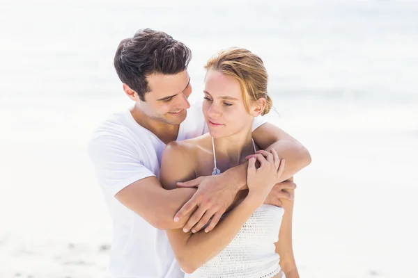 Молодая пара обнимает друг друга на пляже — стоковое фото
