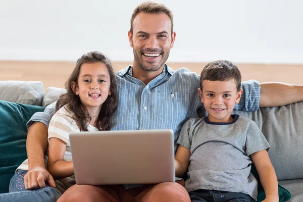 Padre seduto sul divano con figlio e figlia — Foto Stock