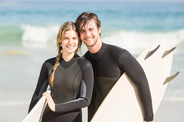 Paar mit Surfbrett steht am Strand — Stockfoto