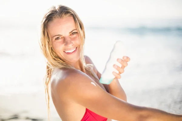 Donna che applica crema solare lozione sulla spiaggia — Foto Stock