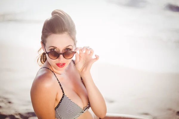 Mujer mirando sobre gafas de sol en la playa —  Fotos de Stock
