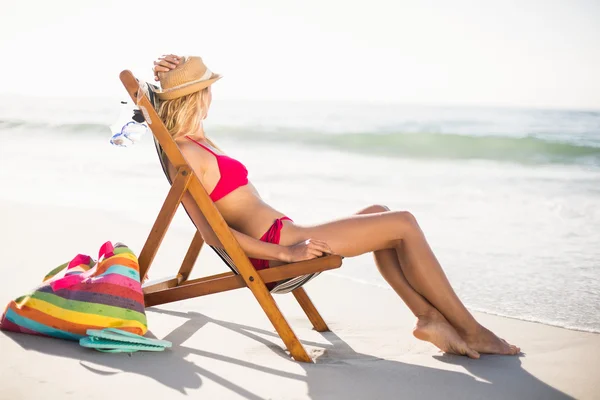 Kvinnan avkopplande på en fåtölj på stranden — Stockfoto