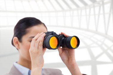 Brunette businesswoman looking through binoculars clipart