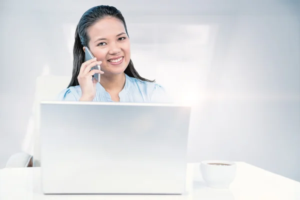 Zakenvrouw op telefoon via laptop — Stockfoto