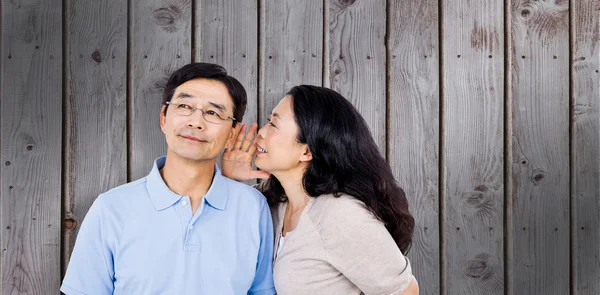 Woman whispering into partners ear — Stock Photo, Image