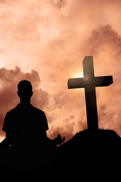 Hombre meditando en la pose de loto contra la cruz — Foto de Stock