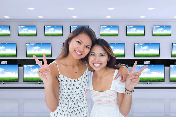 Two smiling young women making a peace gesture — Stock Photo, Image