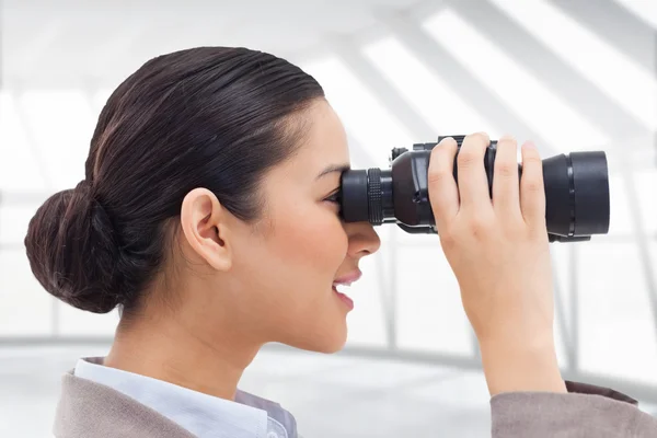 Zakenvrouw kijkt door verrekijker — Stockfoto