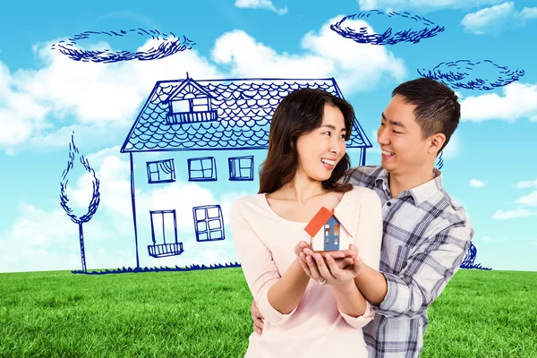 Veselý pár drží model domu — Stock fotografie
