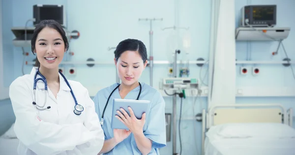 Хирург с помощью цифрового планшета с коллегой — стоковое фото