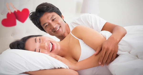 Sorridente coppia sdraiata a letto — Foto Stock