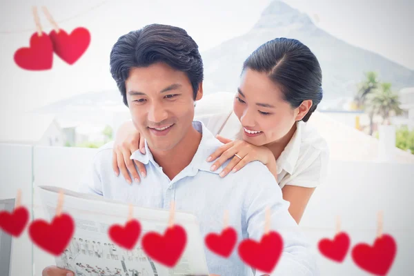 Couple reading newspaper together — Stock Photo, Image