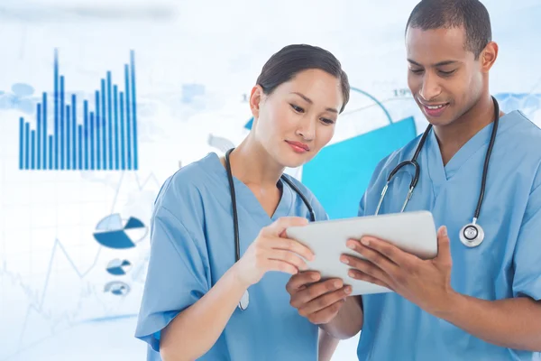 Surgeons looking at digital tablet in hospital — Stock Photo, Image