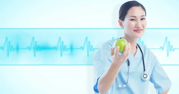 Smiling surgeon holding an apple — Stock Photo, Image