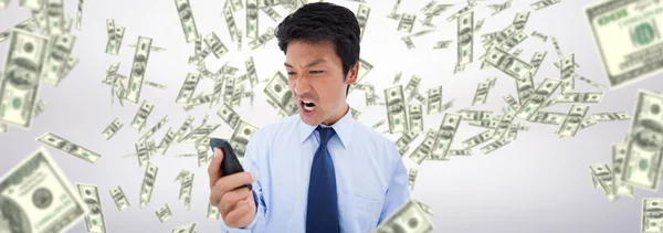 Angry businessman against dollars falling — Stock Photo, Image