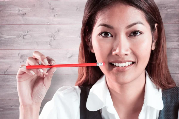 Empresária sorridente segurando um lápis — Fotografia de Stock