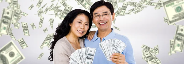Casal sorridente com fãs de dinheiro — Fotografia de Stock