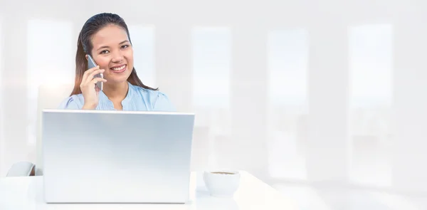 Businesswoman on phone using laptop — Stock Photo, Image