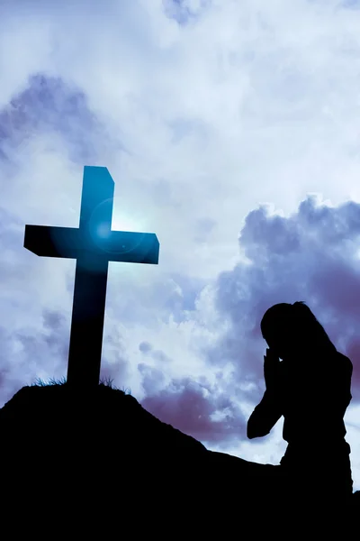 Businesswoman in lotus pose against cross — Stock Photo, Image