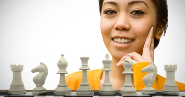 Woman against white chess pieces — Stock Photo, Image