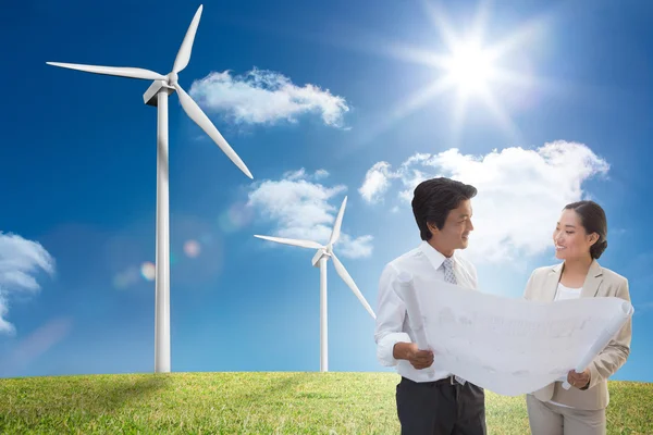 Estate agent looking at blueprint with potential buyer — Stock Photo, Image