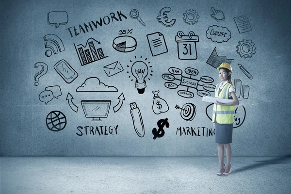 Arquitecta mujer con casco amarillo y planos — Foto de Stock