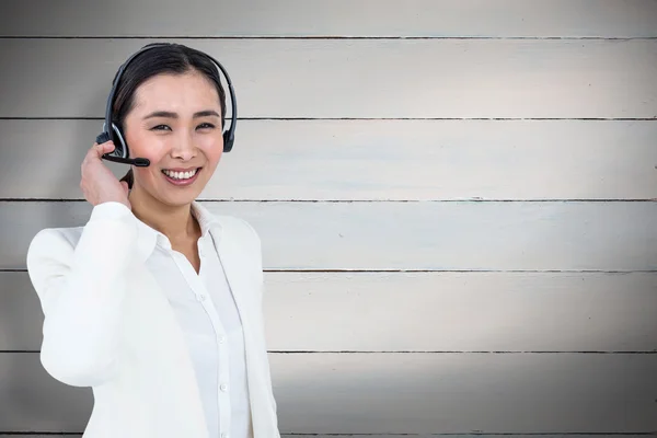 Mulher de negócios sorrindo usando fone de ouvido — Fotografia de Stock