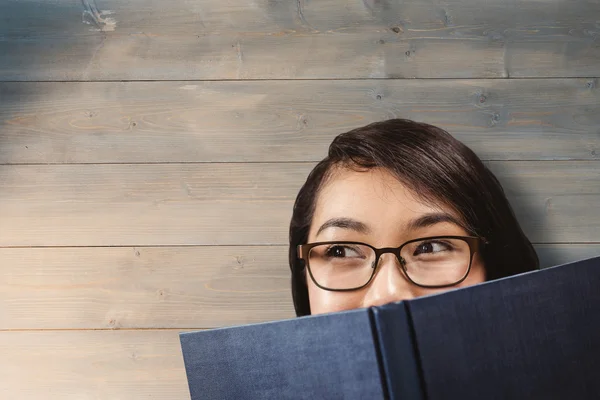 Student som döljer ansiktet bakom en bok — Stockfoto