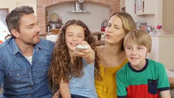 Famille utilisant la télécommande sur le canapé — Video