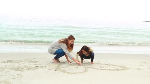 Madre e hija dibujando en la arena — Vídeo de stock