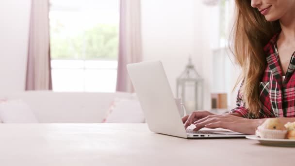 Mulher usando laptop com muffins — Vídeo de Stock