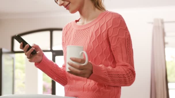 Brunette using smartphone while drinking coffee — Stock Video