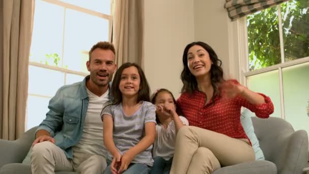 Glückliche Familie auf dem Sofa jubelt — Stockvideo