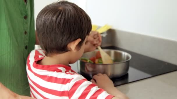 Mignon garçon essayant de cuisiner avec sa mère — Video