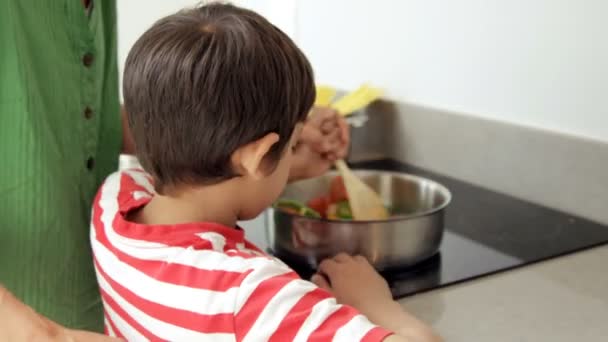 Netter Junge versucht, mit seiner Mutter zu kochen — Stockvideo