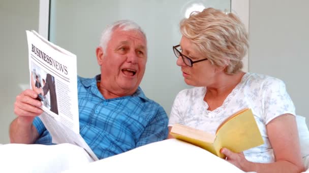 Sonriendo pareja mayor leyendo el periódico — Vídeos de Stock